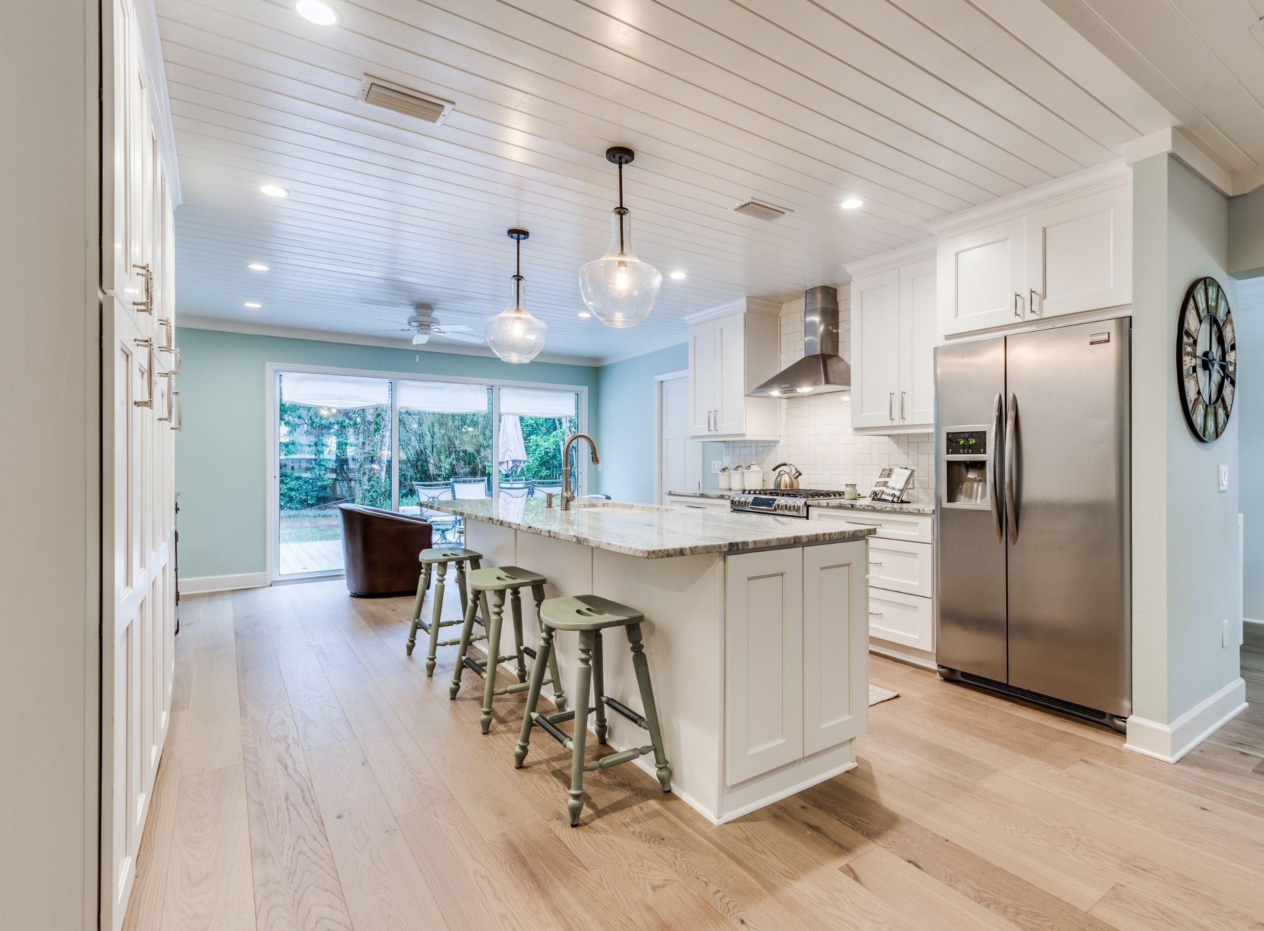 atlantic beach kitchen remodel with white cabinets, island bar stools, and shiplap ceiling