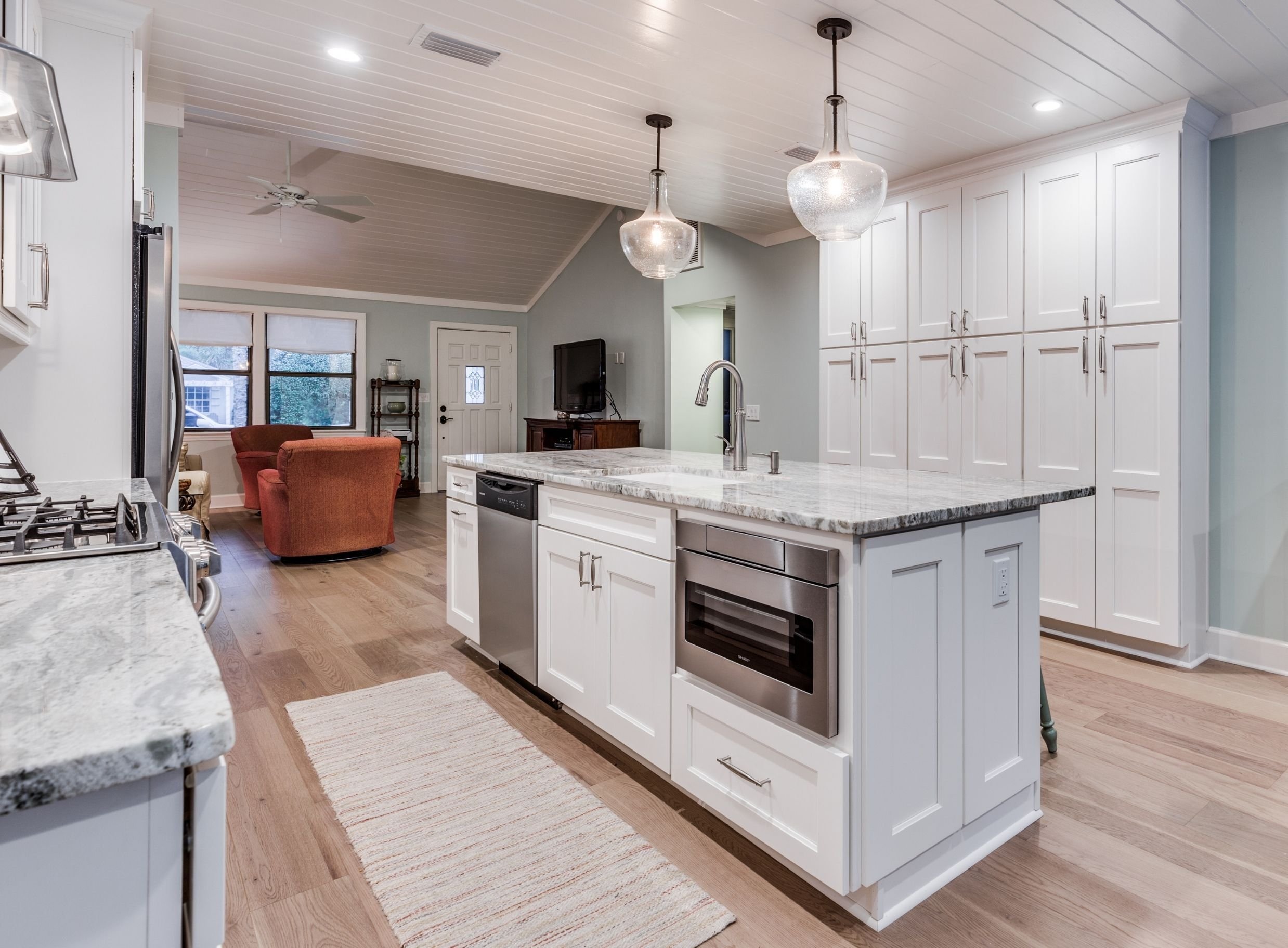 small kitchen island with stainless steel microwave and dishwasher