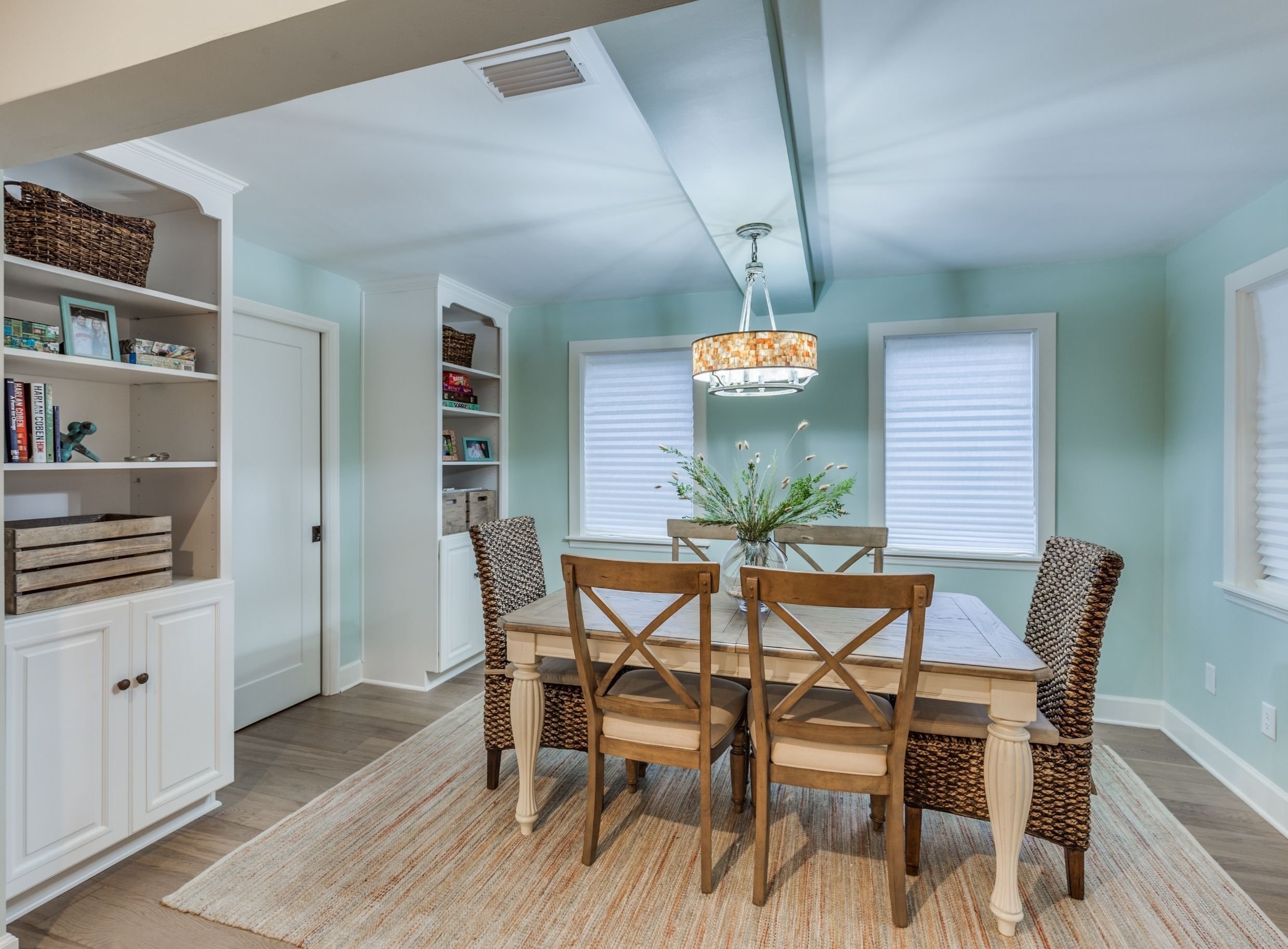 turquoise and white coastal dining room design in atlantic beach with white built ins and pocket door