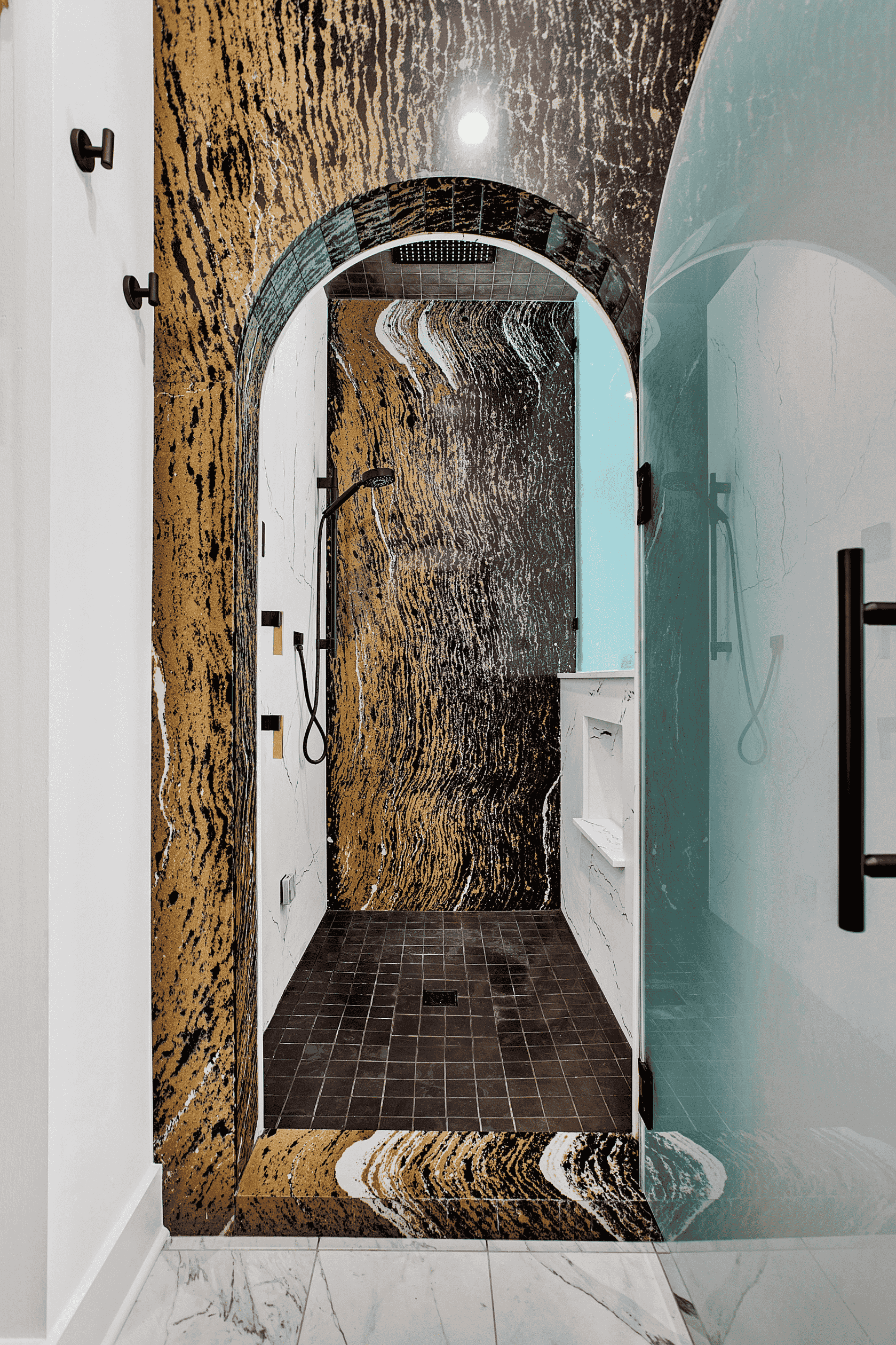 walk in shower with arched frosted glass door in a luxury master bathroom remodel