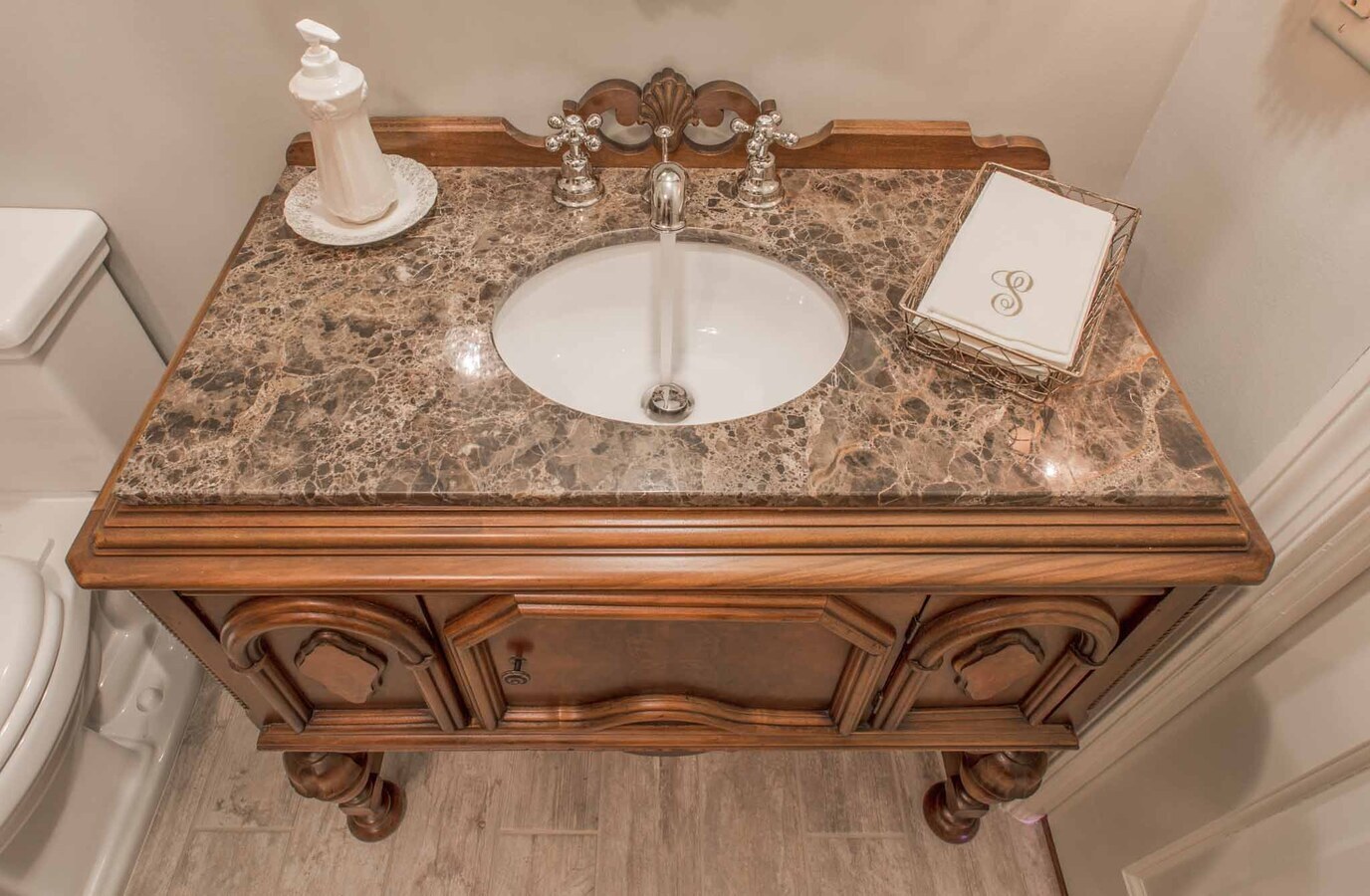 Bathroom vanity with marble countertop and traditional woodwork in BeeTree Homes custom home