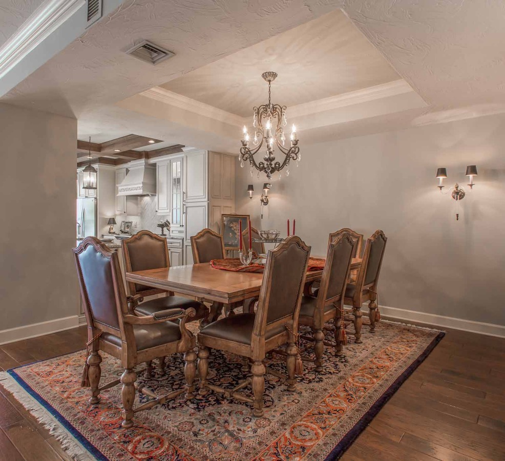 Formal dining space with ornate lighting and wood trim, designed by BeeTree Homes in a Jacksonville, FL