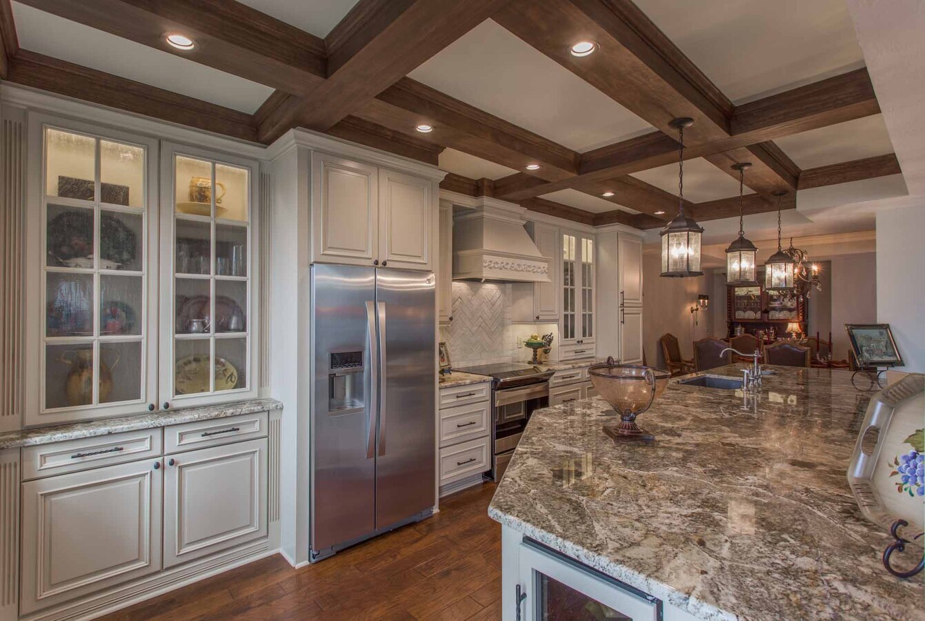 Gourmet kitchen with coffered ceiling and granite island in Jacksonville, FL custom home by BeeTree Home