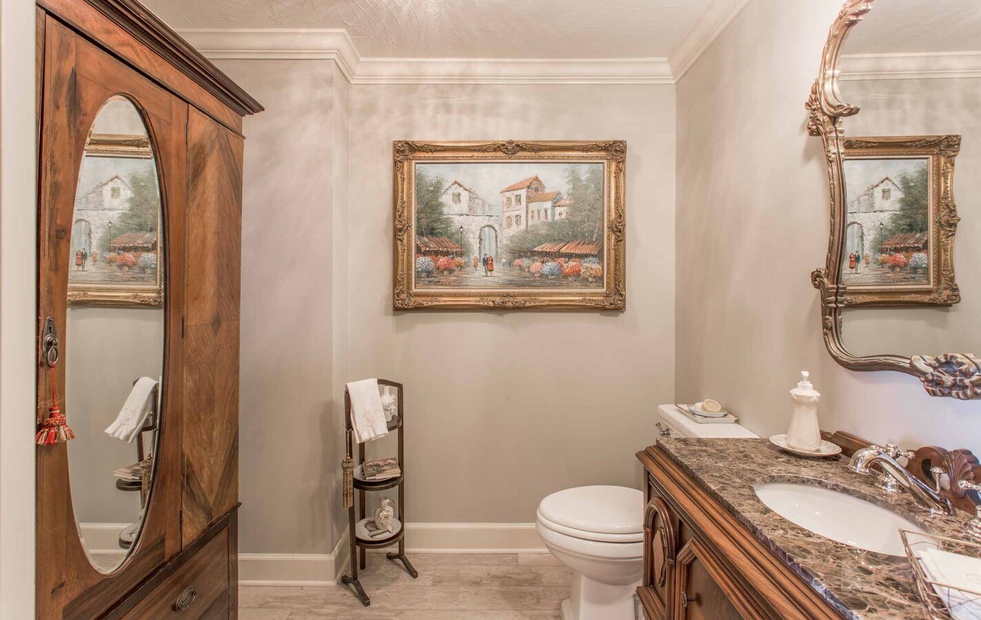 Traditional powder room with framed wall art and marble vanity in custom BeeTree Homes home Jacksonville