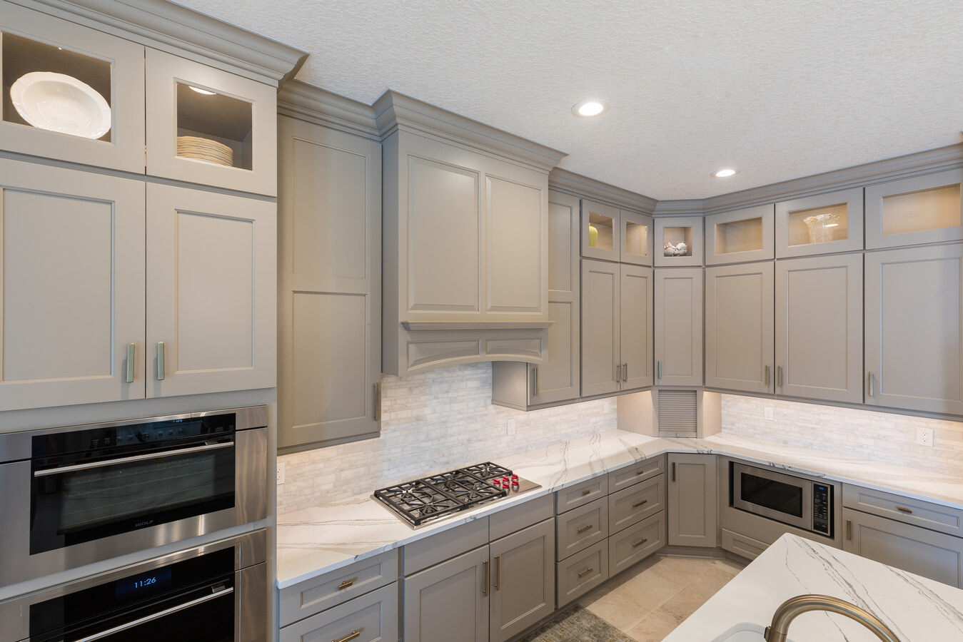 Contemporary kitchen remodel with gas cooktop and marble backsplash by BeeTree Homes in Neptune Beach, FL