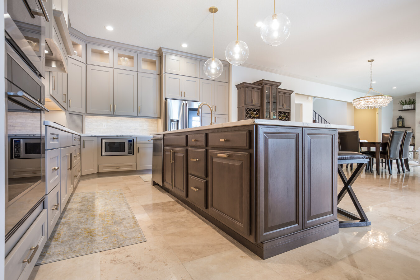 Custom kitchen island with rich wood cabinetry and pendant lighting by BeeTree Homes in Jacksonville, FL