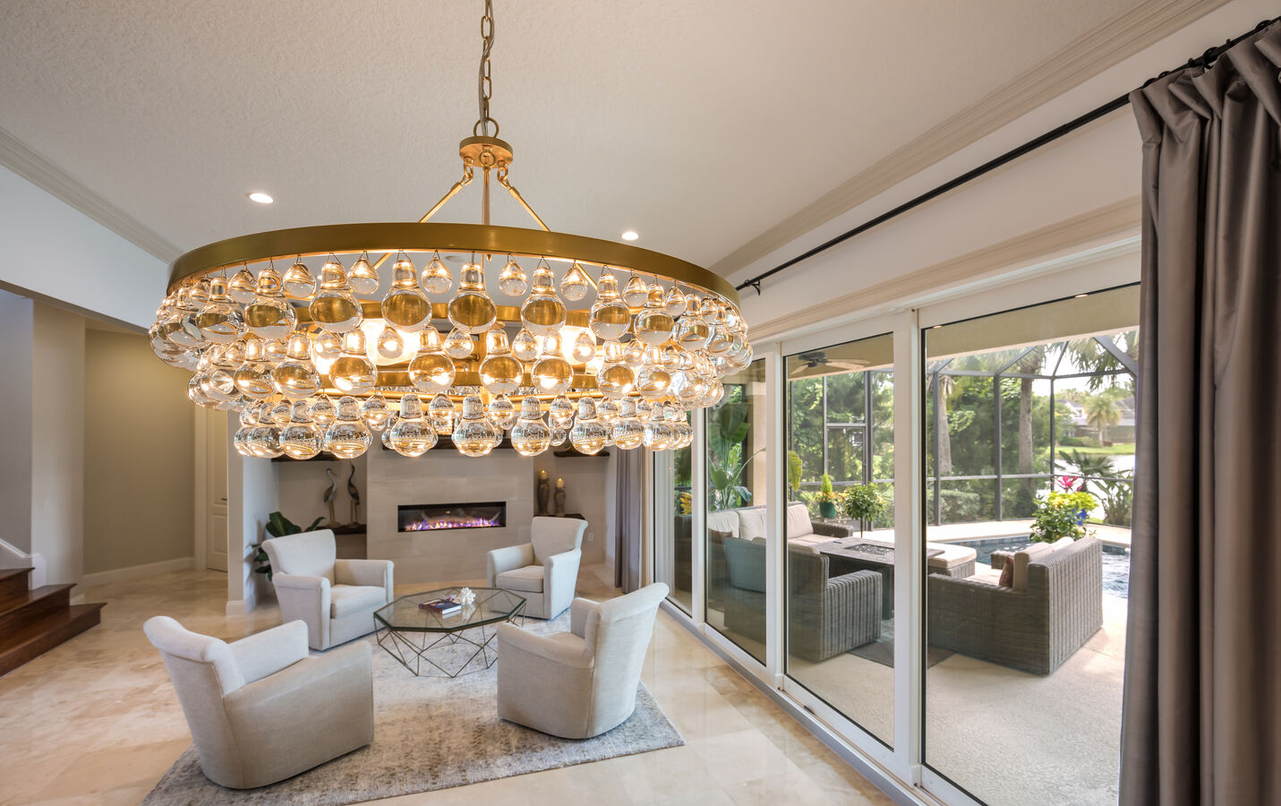 Luxury dining room with crystal chandelier overlooking pool by BeeTree Homes in Baymeadows, FL