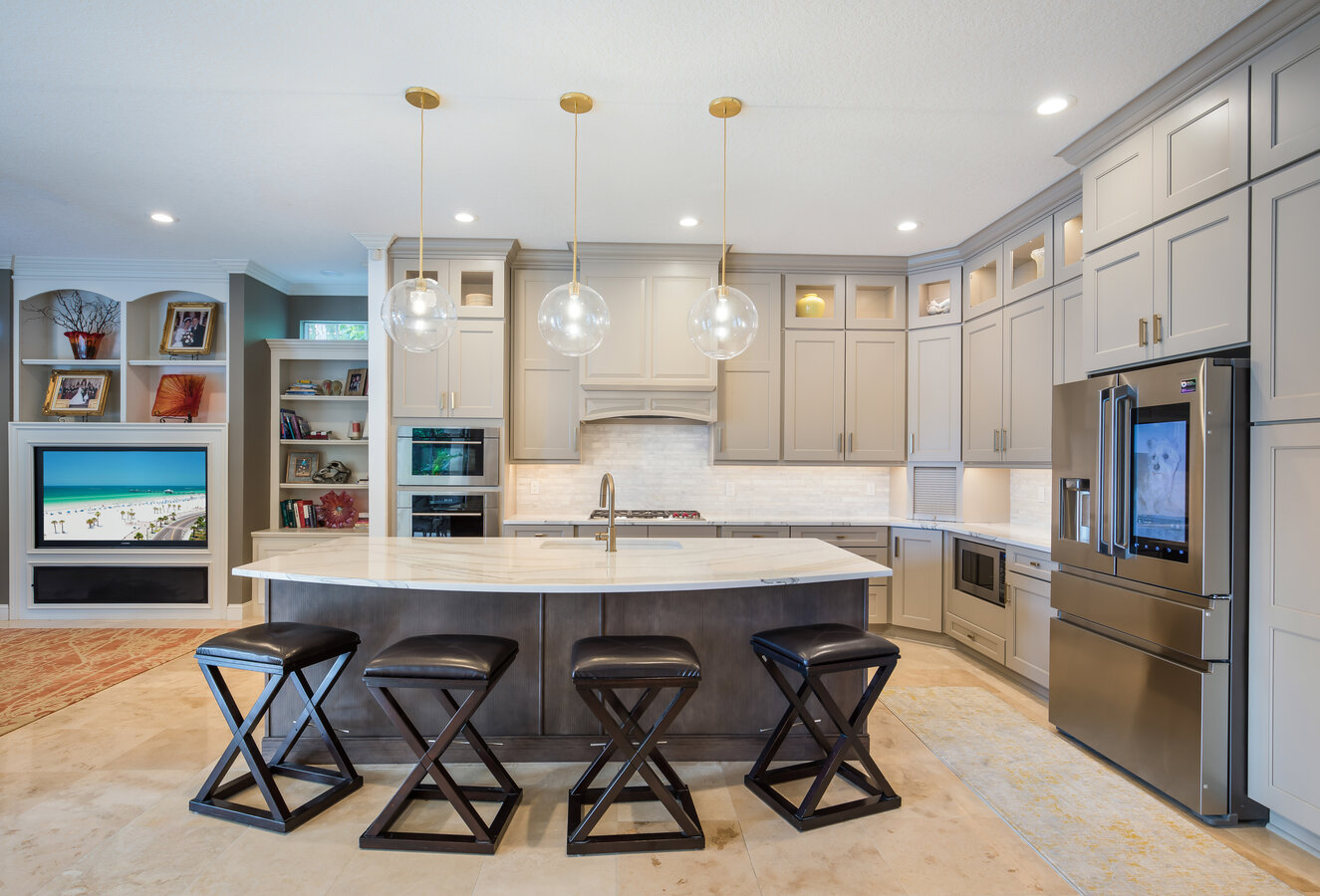Modern custom kitchen remodel by BeeTree Homes in Jacksonville, FL, featuring gray cabinetry, marble island, and pendant lighting