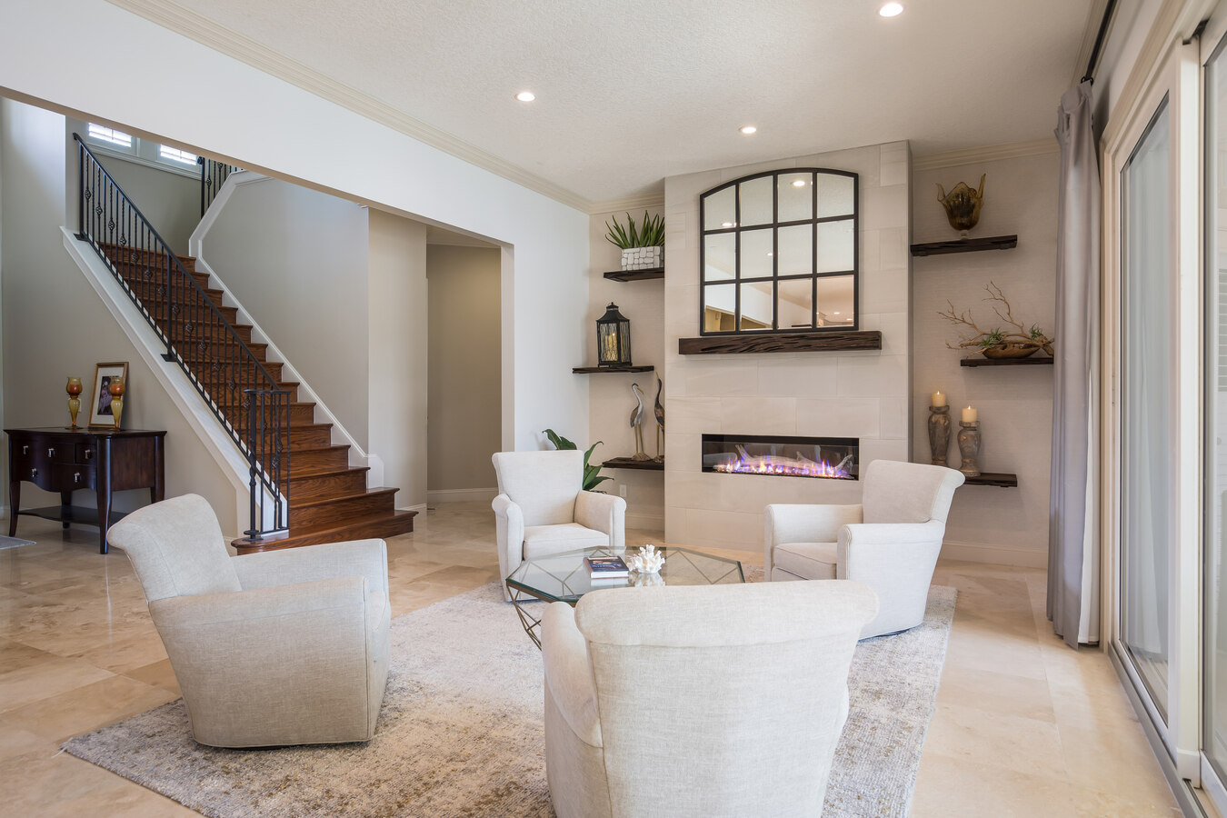 Modern living space with staircase and fireplace by BeeTree Homes in Queens Harbour, FL