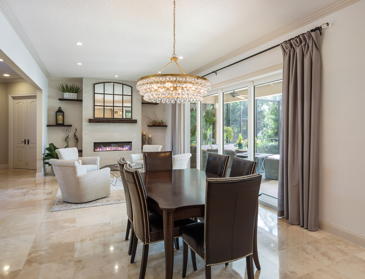 Stylish dining room design by BeeTree Homes in Intracoastal West, FL with modern lighting and outdoor views