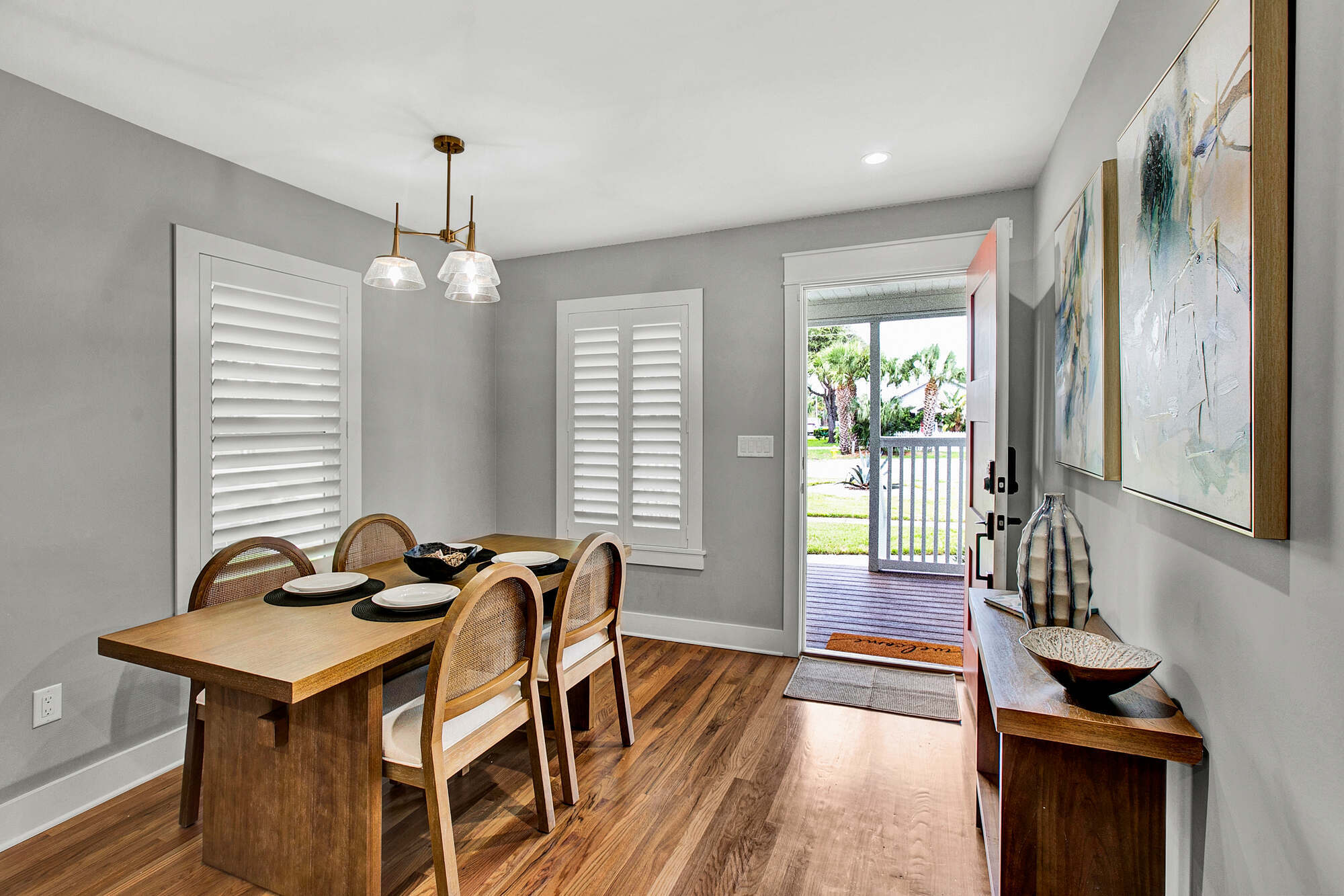 Modern dining area inside ADU beach house in Jacksonville, Florida by BeeTree Homes featuring wood floors, natural light, and coastal-inspired décor