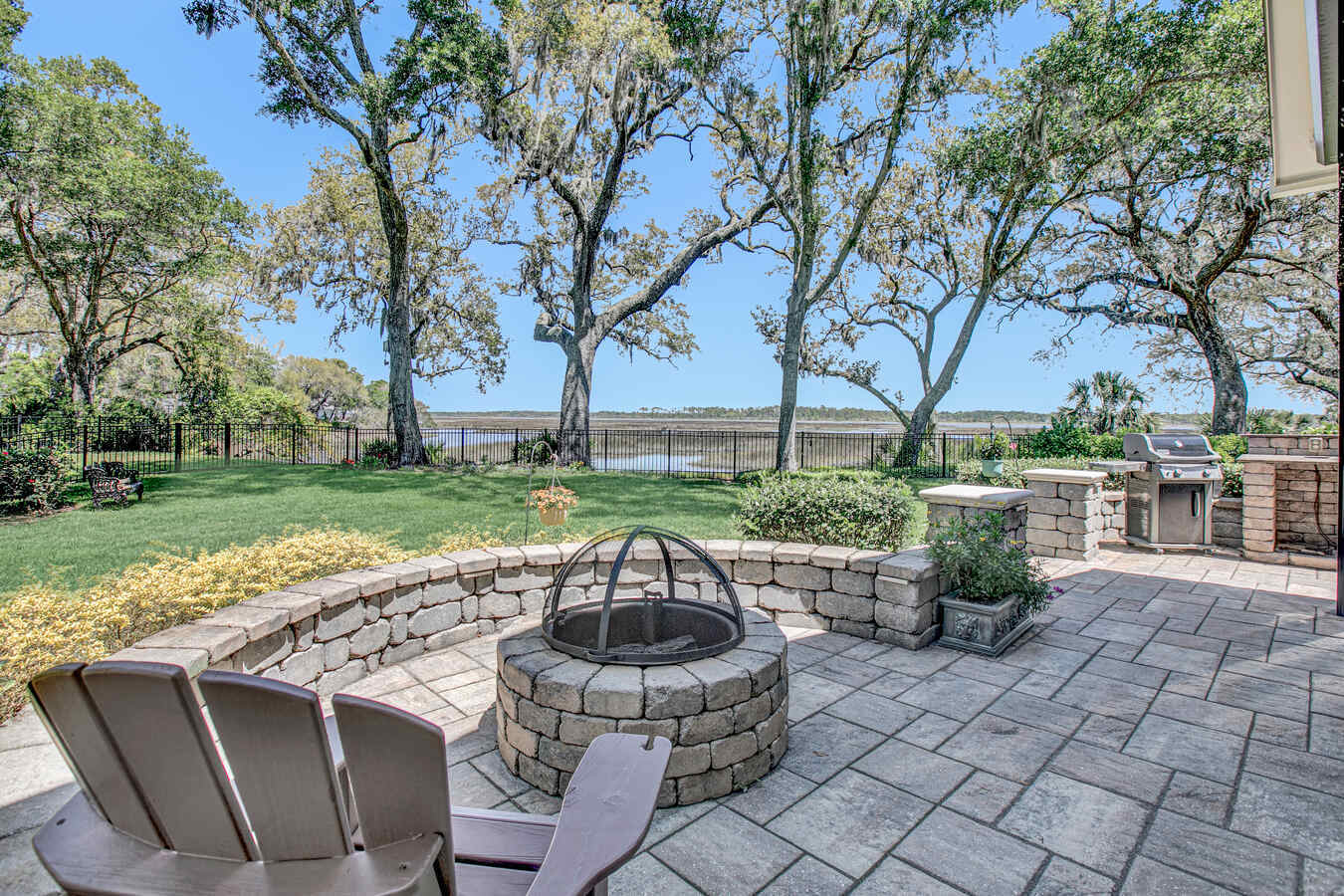 Backyard paver patio with fire feature and grill station in custom Jacksonville home by BeeTree