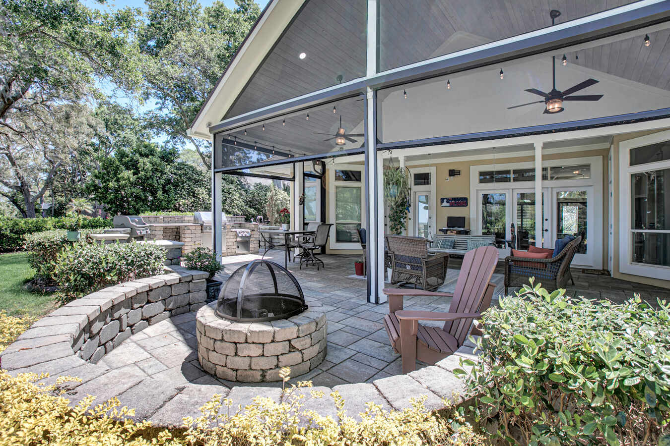 Brick fire pit and patio with Adirondack chairs in custom BeeTree Homes build in Jacksonville