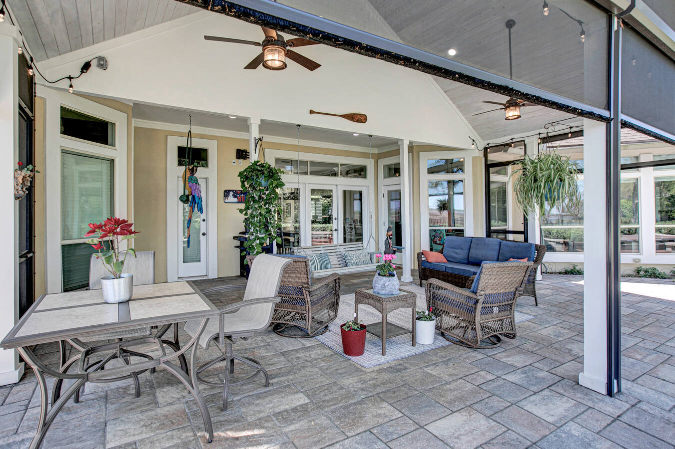 Covered lanai with patio furniture and potted plants by BeeTree Homes, Jacksonville, FL