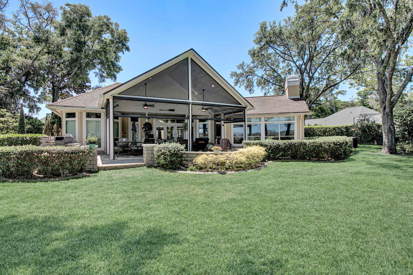 Exterior view of screened patio and manicured lawn in custom BeeTree Homes project in Jacksonville