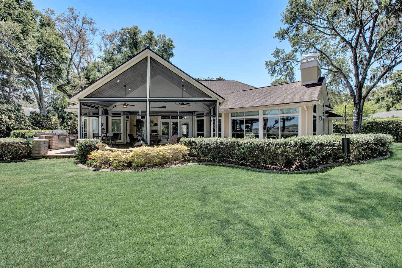 Rear view of custom Jacksonville home with outdoor living space by BeeTree Homes