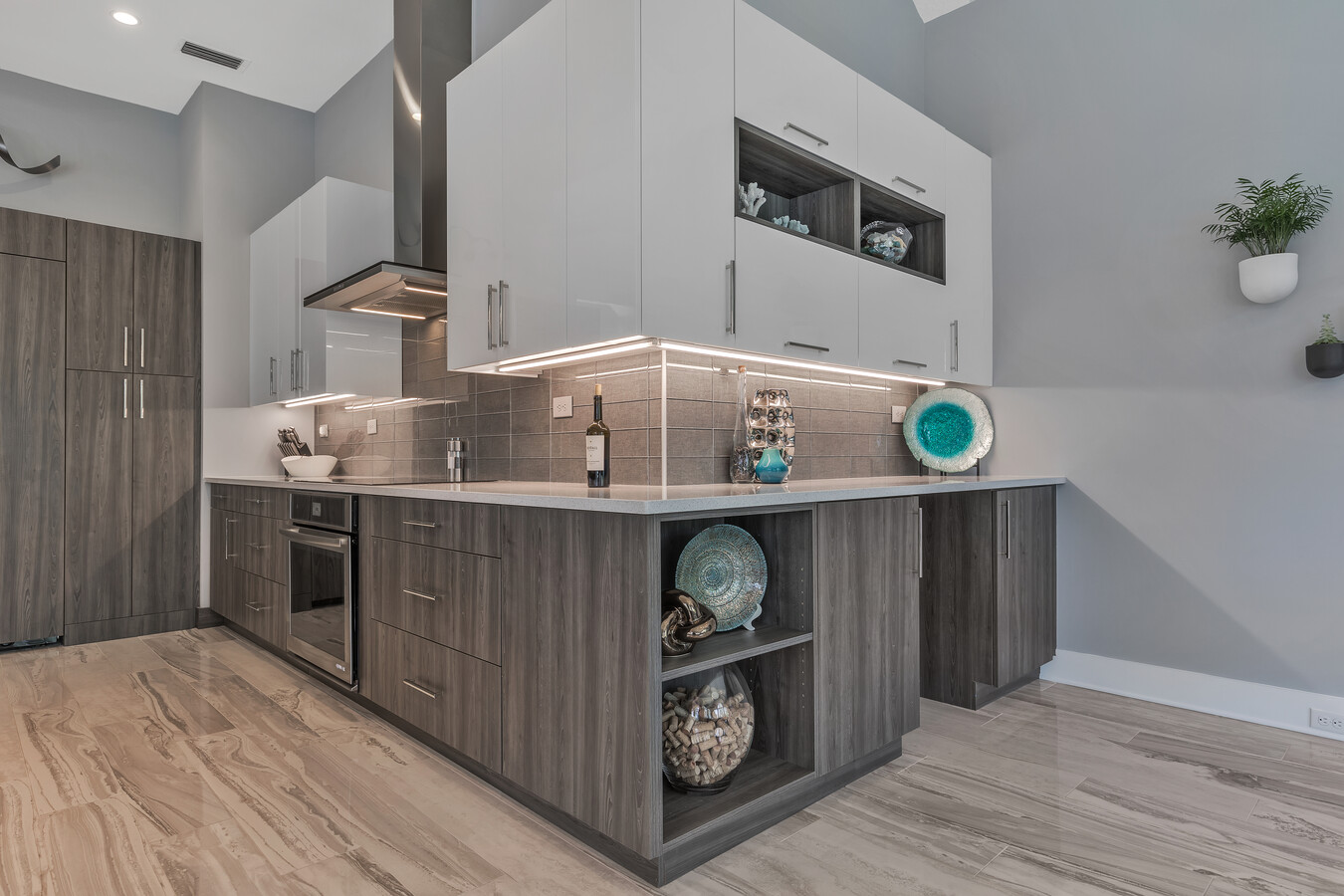 Modern kitchen corner with accent shelving and glass backsplash by BeeTree Homes Jacksonville
