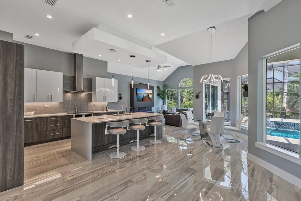 Open concept kitchen and living space with poolside views by BeeTree Homes in Jacksonville, FL