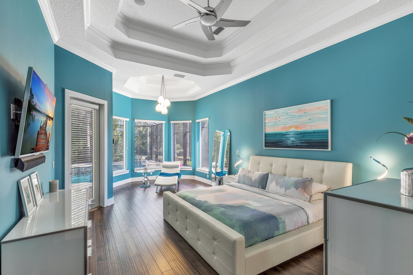 Vibrant master bedroom with tray ceiling and large windows in a BeeTree Homes custom home