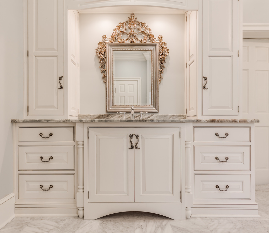 Custom bathroom cabinetry with ornate gold mirror in a luxury BeeTree Homes home in Jacksonville, FL
