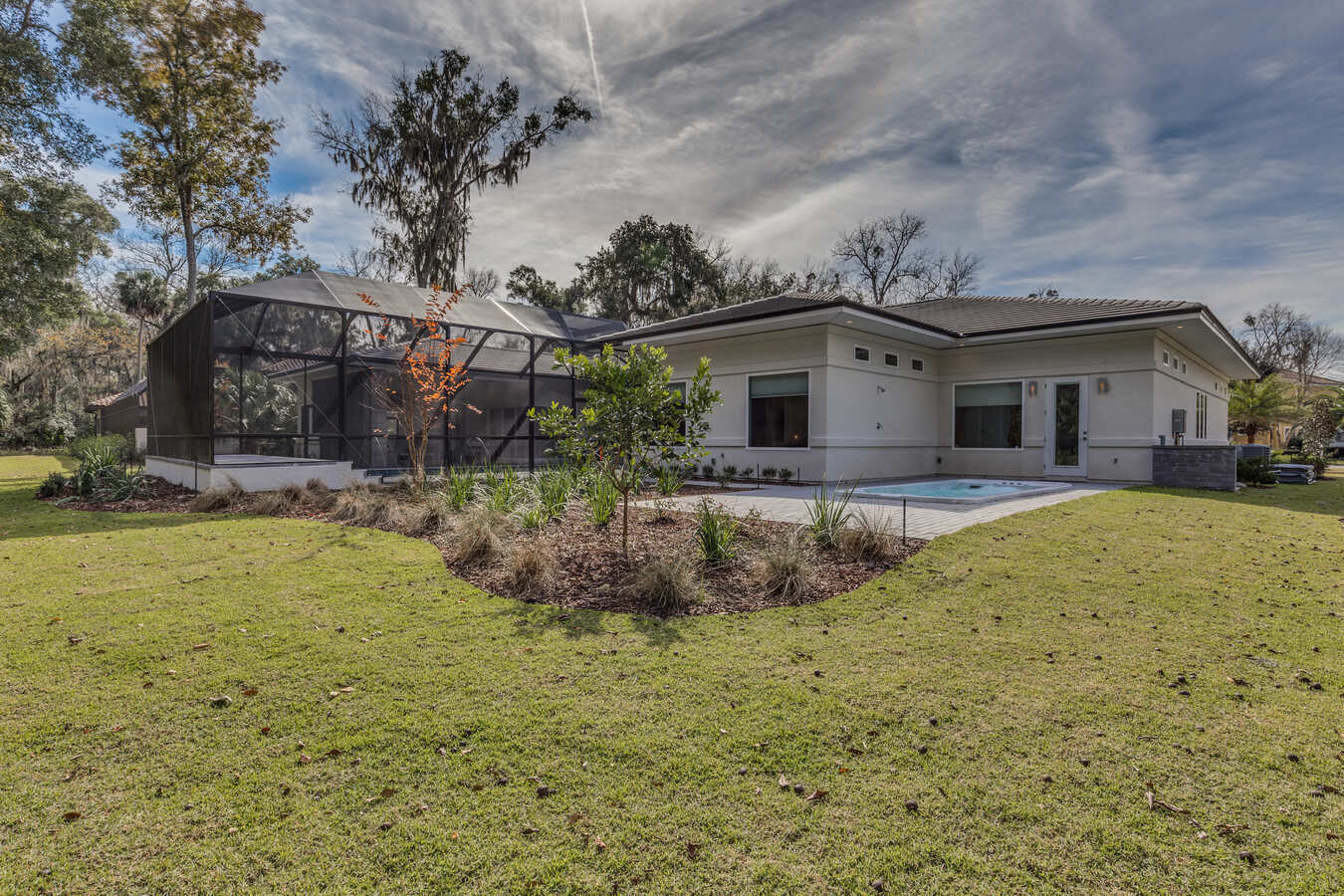 BeeTree Homes Jacksonville custom home featuring a screened pool area and open lawn