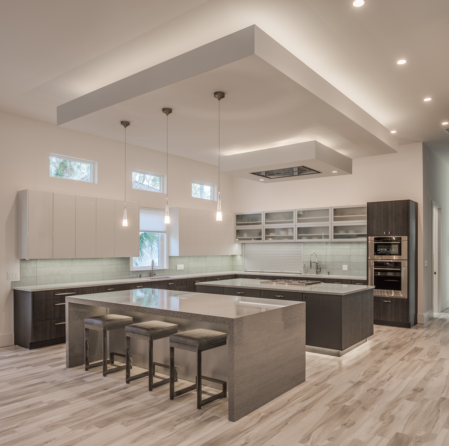Sleek kitchen with pendant lights and open layout by BeeTree Homes in Jacksonville, FL