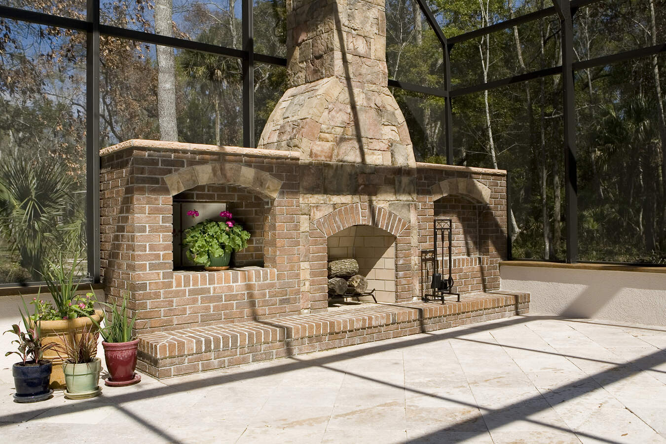 Stone and brick fireplace detail in outdoor lounge area of Jacksonville custom home by BeeTree Homes