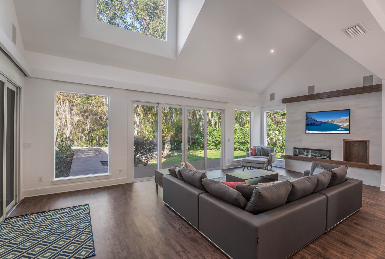 Bright living room with vaulted ceilings and scenic backyard views in custom home by BeeTree Homes Bright living room with vaulted ceilings and scenic backyard views in custom home by BeeTree Homes