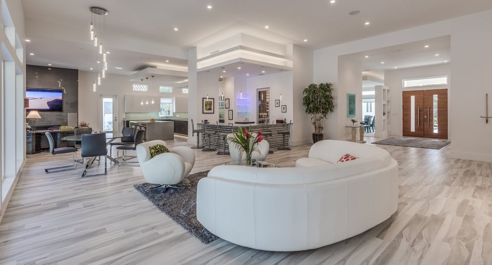 Jacksonville, FL luxury living area by BeeTree Homes with white leather furniture and modern lighting