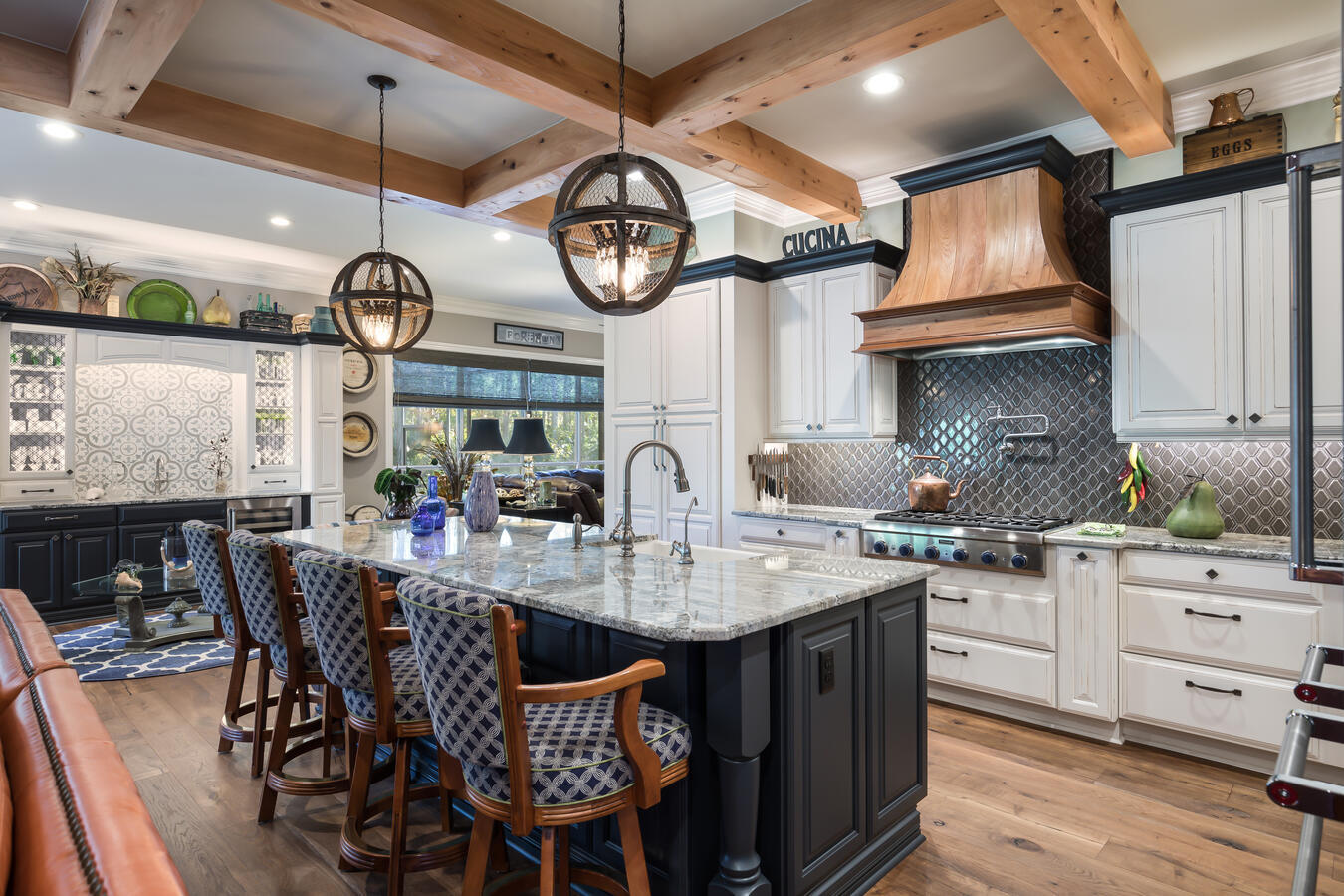 Luxury kitchen design featuring granite island, globe pendant lights, and custom hood by BeeTree Homes
