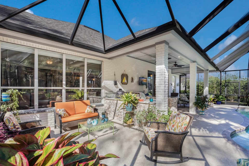 Enclosed patio with cozy seating and potted plants at BeeTree Homes custom build in Jacksonville, FL