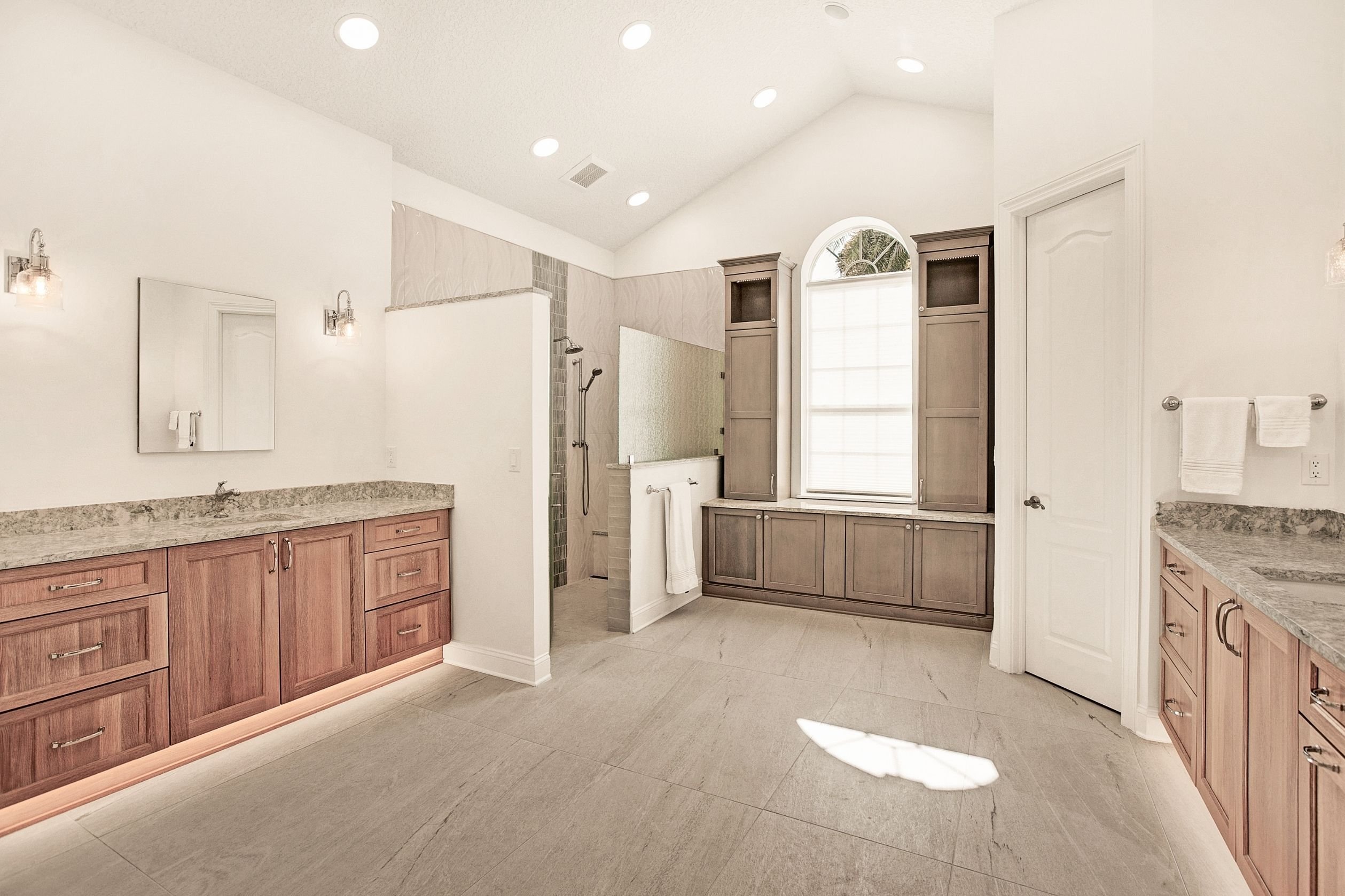 large primary bathroom with his and hers vanities and a large walk in shower