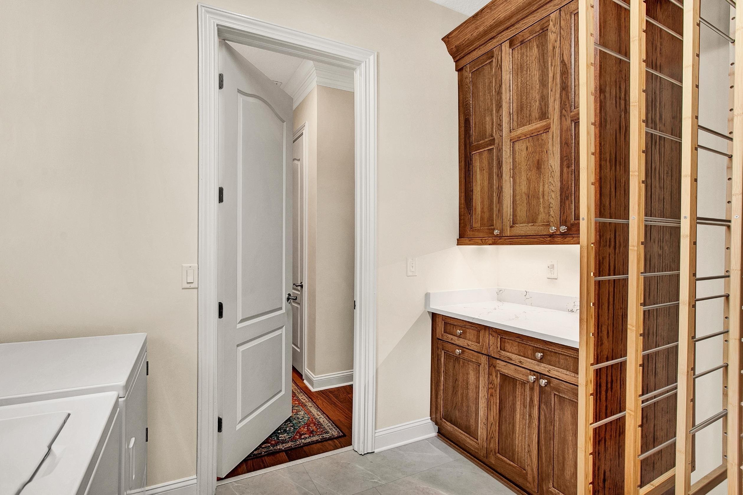 laundry room with wood cabinets and drying racks