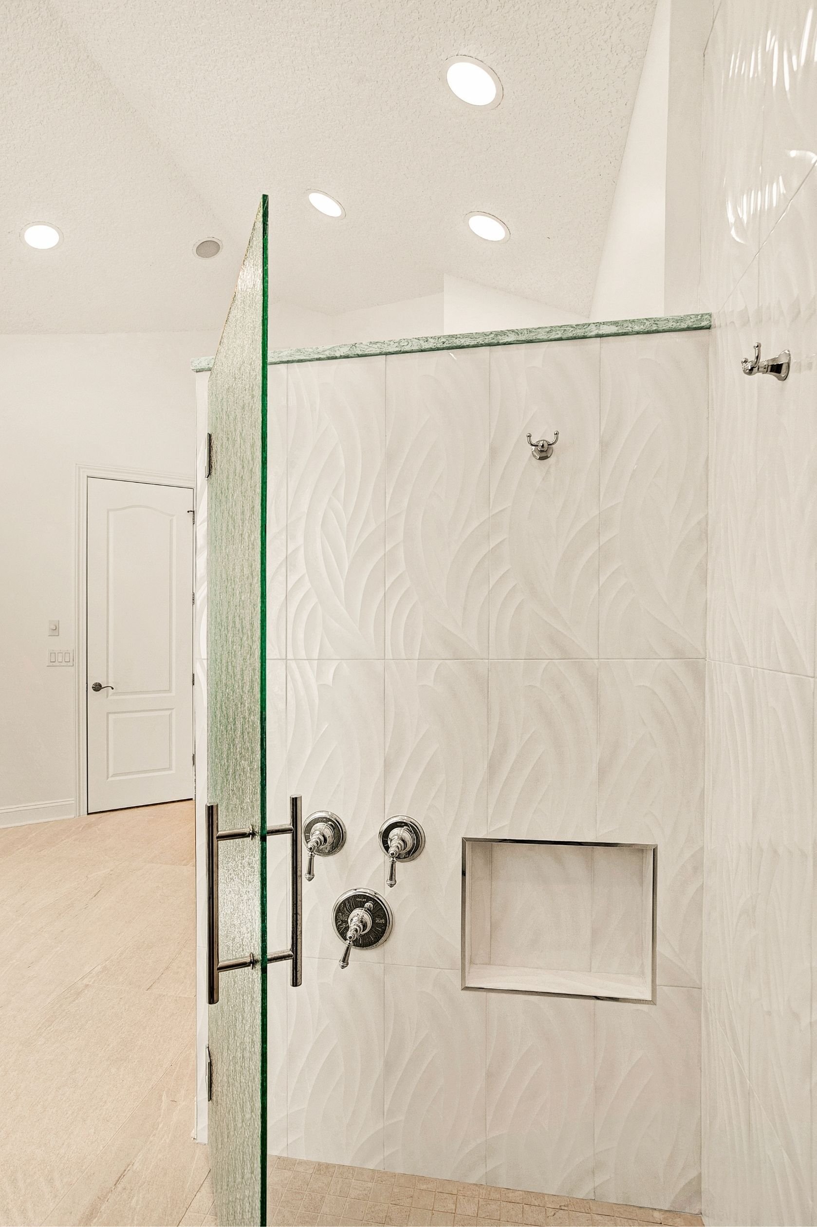 walk in shower with white tile and glass door in a jacksonville bathroom remodel