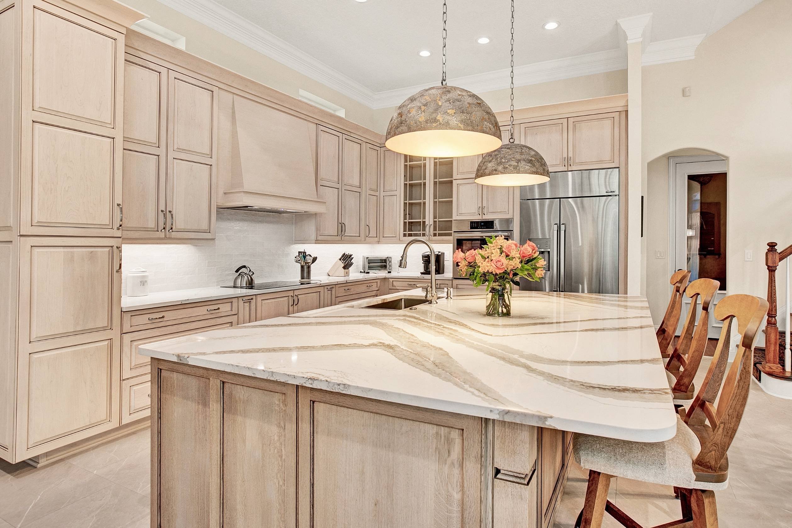 warm neutral kitchen remodel with bar stool seating at kitchen island