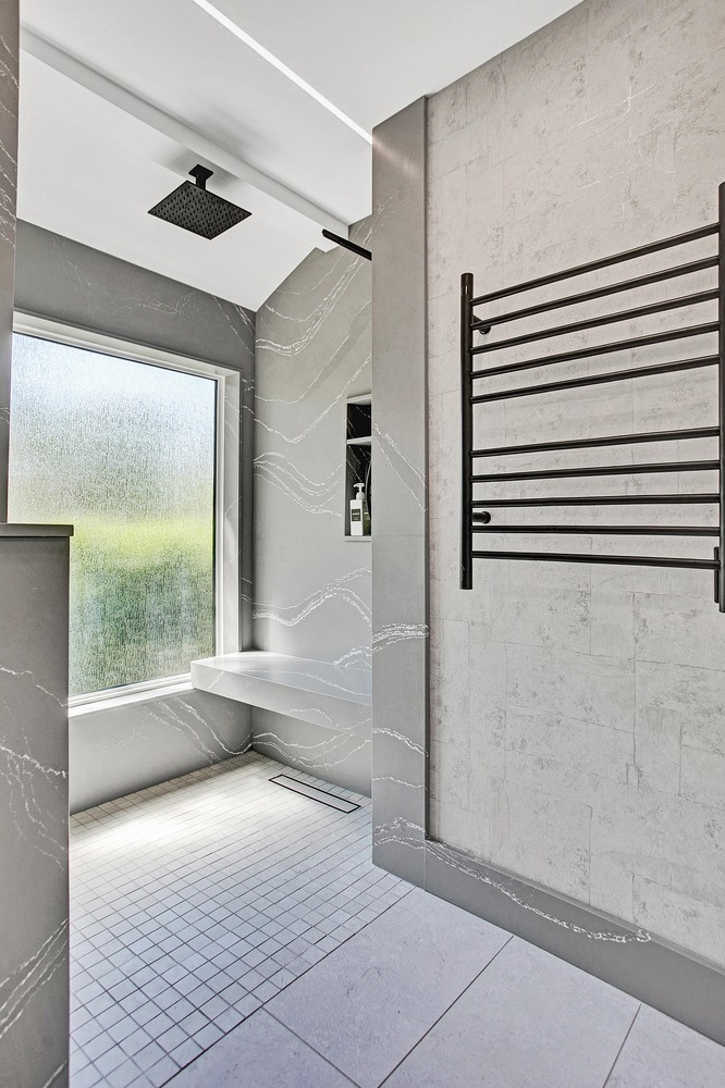 walk-in shower with bench seating and rainfall showerhead in BeeTree Homes custom home Jacksonville FL