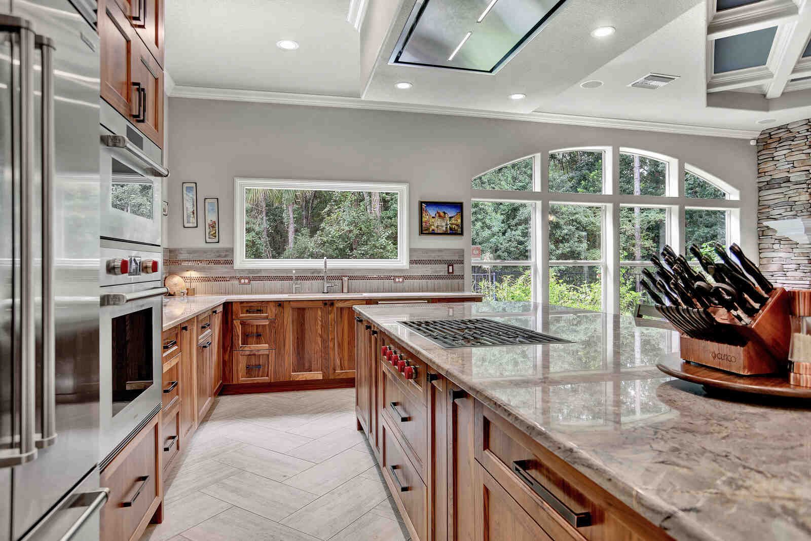 Eclectic whole home remodel kitchen island view with gas range, built-in ovens, and refrigerator