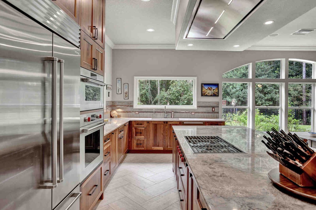 Eclectic whole home remodel kitchen island view with gas range, built-in ovens, and refrigerator