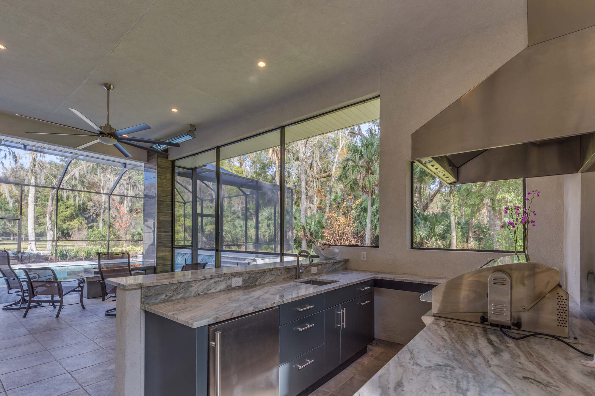 Covered outdoor kitchen with marble countertops in BeeTree Homes custom Jacksonville home
