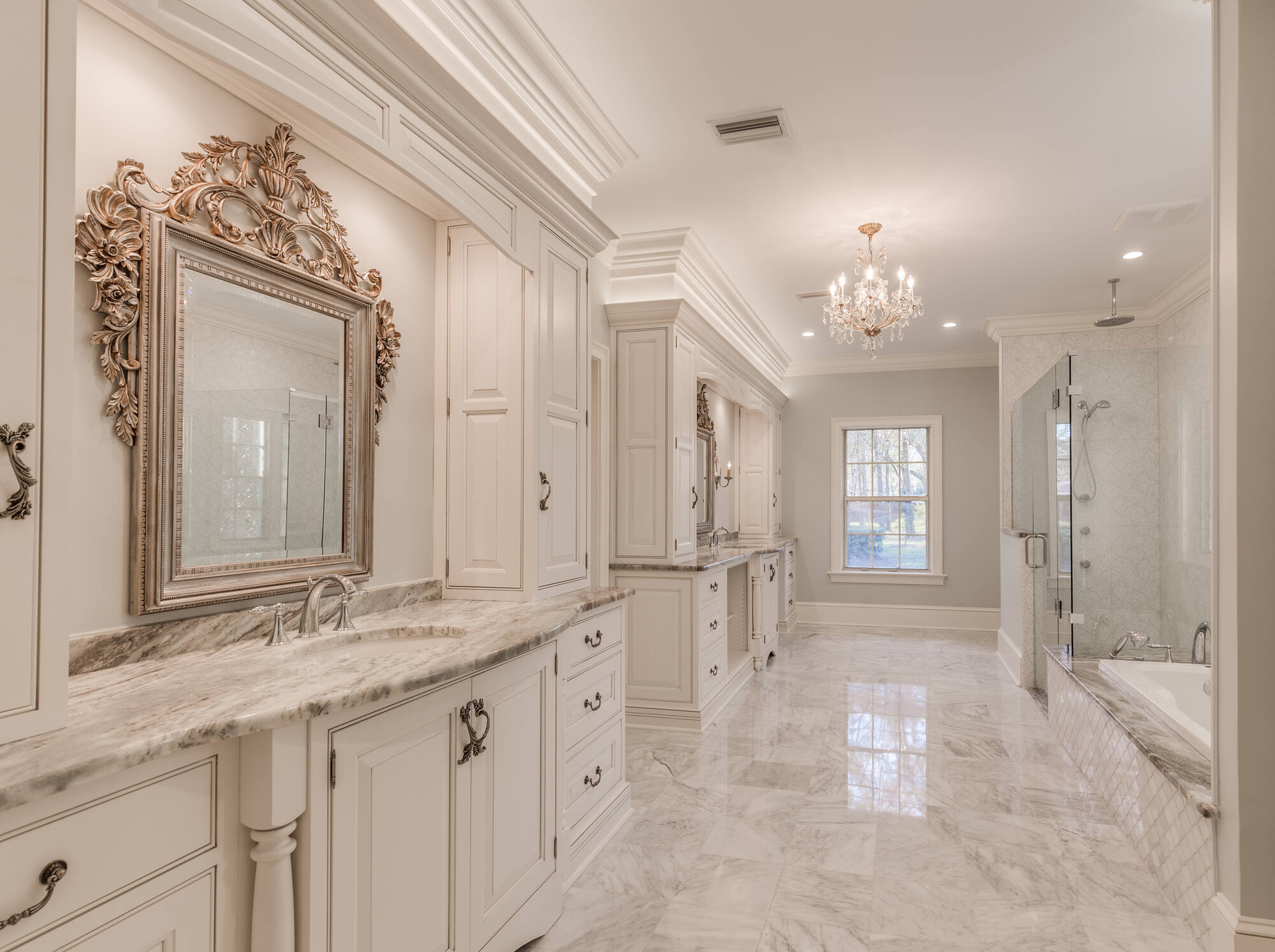 Luxury primary bathroom with ornate mirrors and marble floors in a BeeTree Homes custom build in Jacksonville, FL Luxury primary bathroom with ornate mirrors and marble floors in a BeeTree Homes custom build in Jacksonville, FL