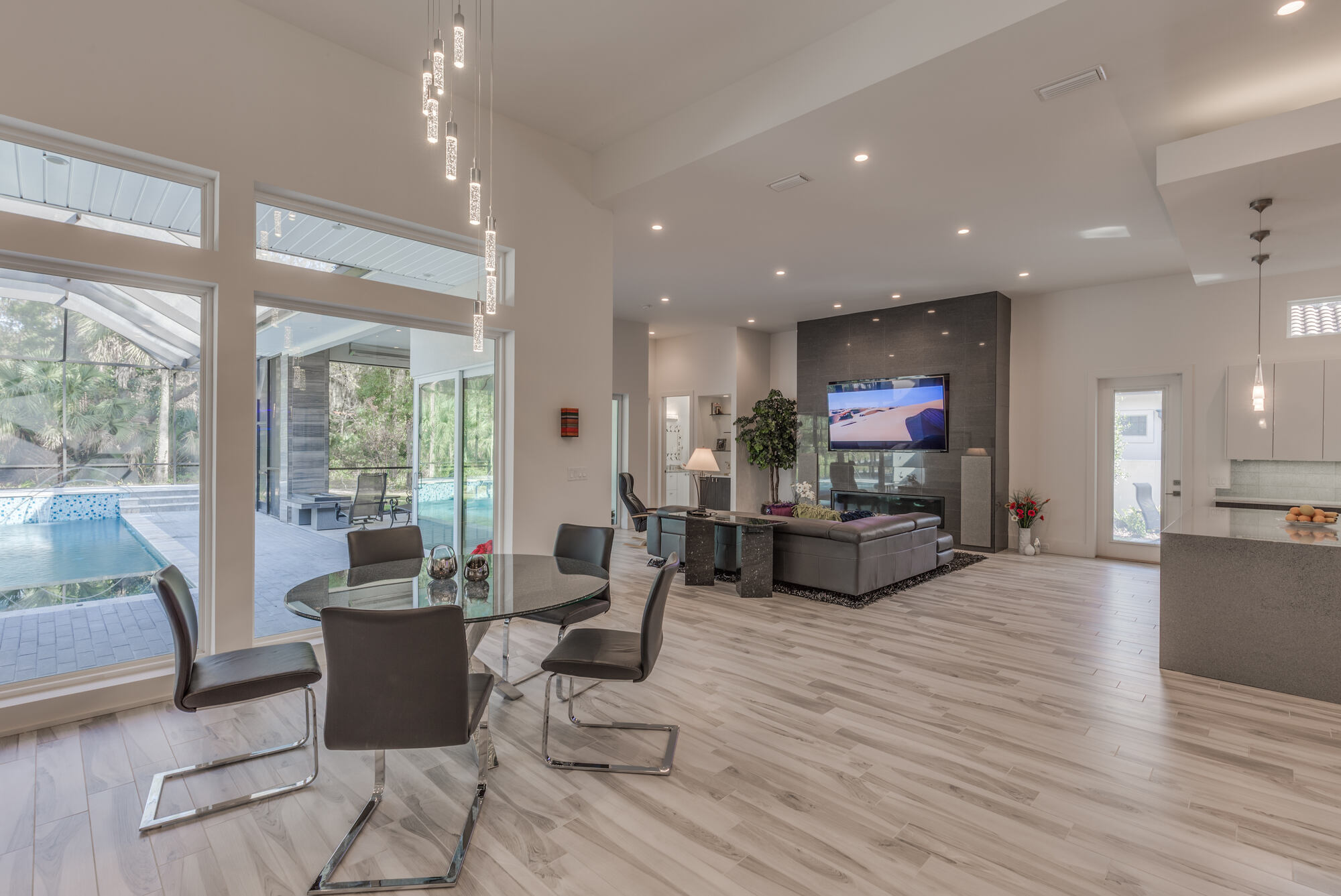 Open dining and living area with large windows and pool view in a BeeTree Homes custom home in Jacksonville, FL