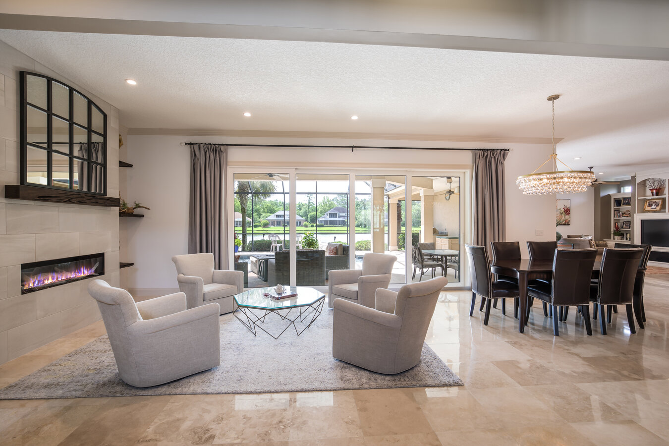 Luxury home interior in Atlantic Beach, FL by BeeTree Homes with modern fireplace and expansive windows