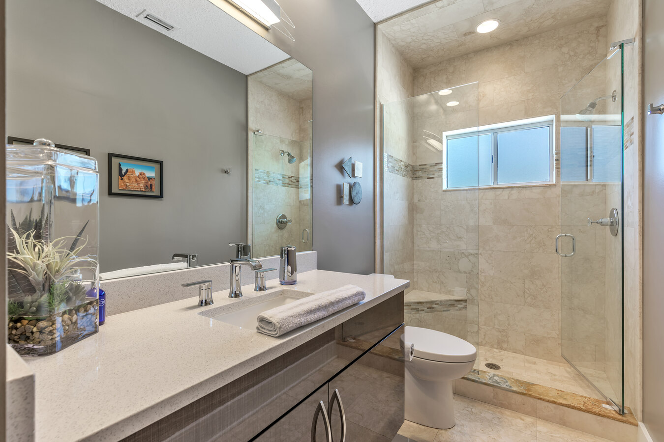 Custom bathroom design with frameless glass shower and elegant finishes by BeeTree Homes