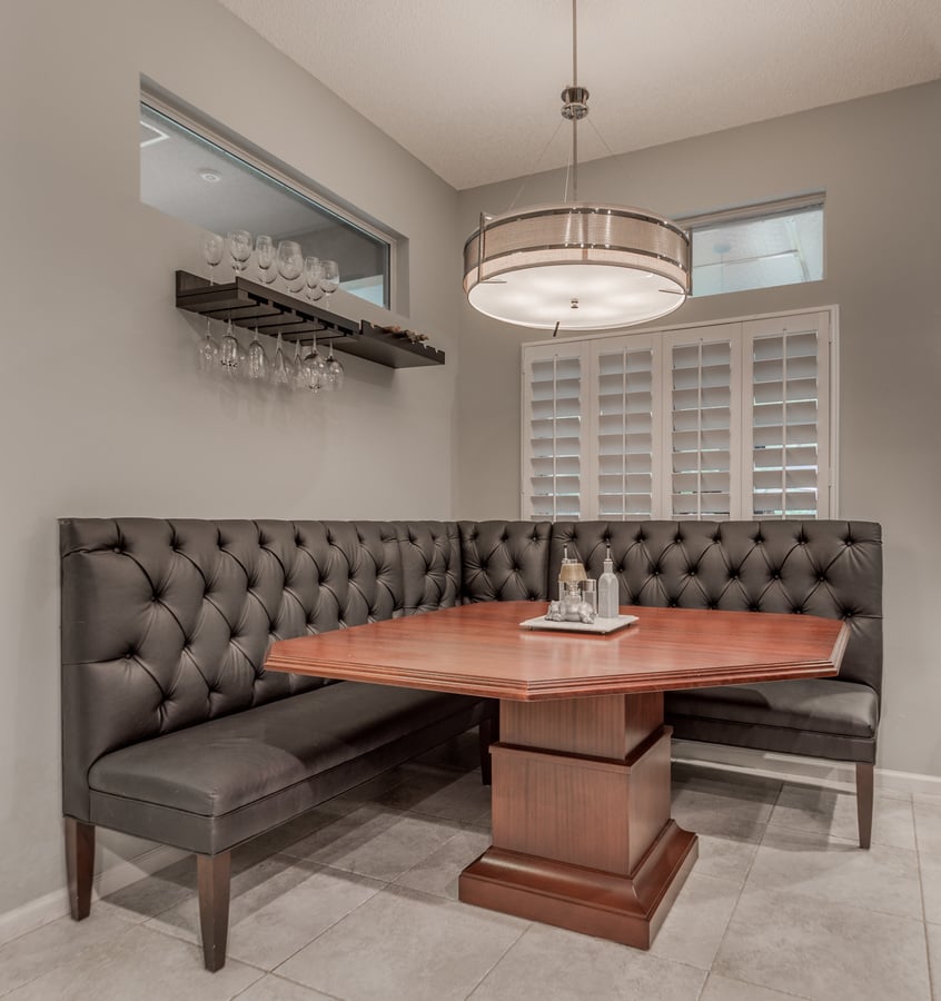 Jacksonville, FL kitchen banquette with wood table and modern chandelier by BeeTree Homes
