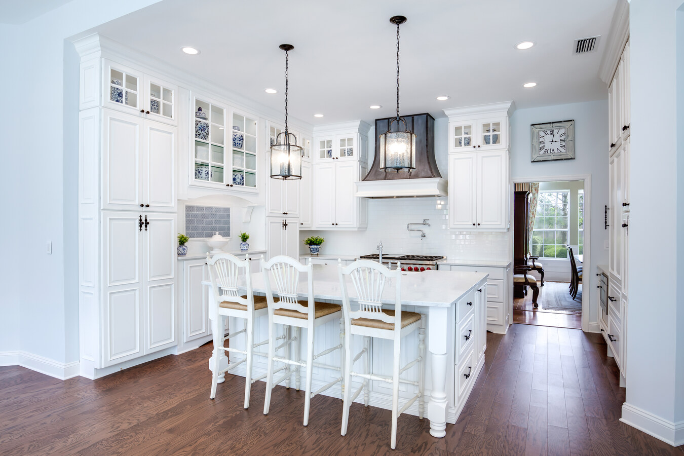 Elegant custom kitchen with pendant lighting and classic white finishes by BeeTree Homes